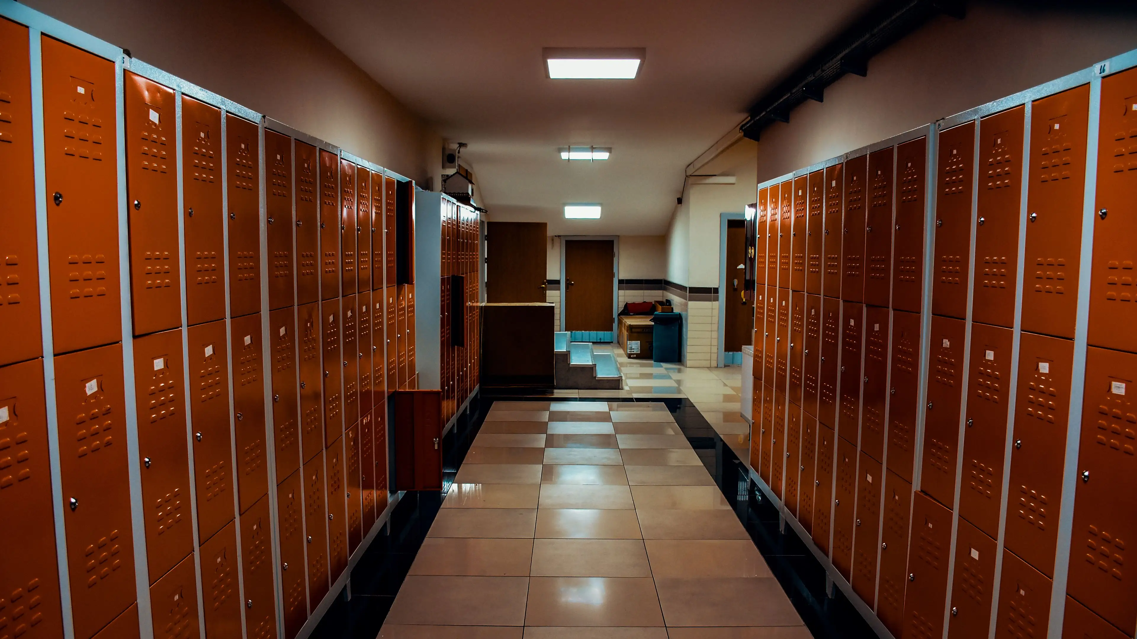 A corridor lined with orange gym lockers
