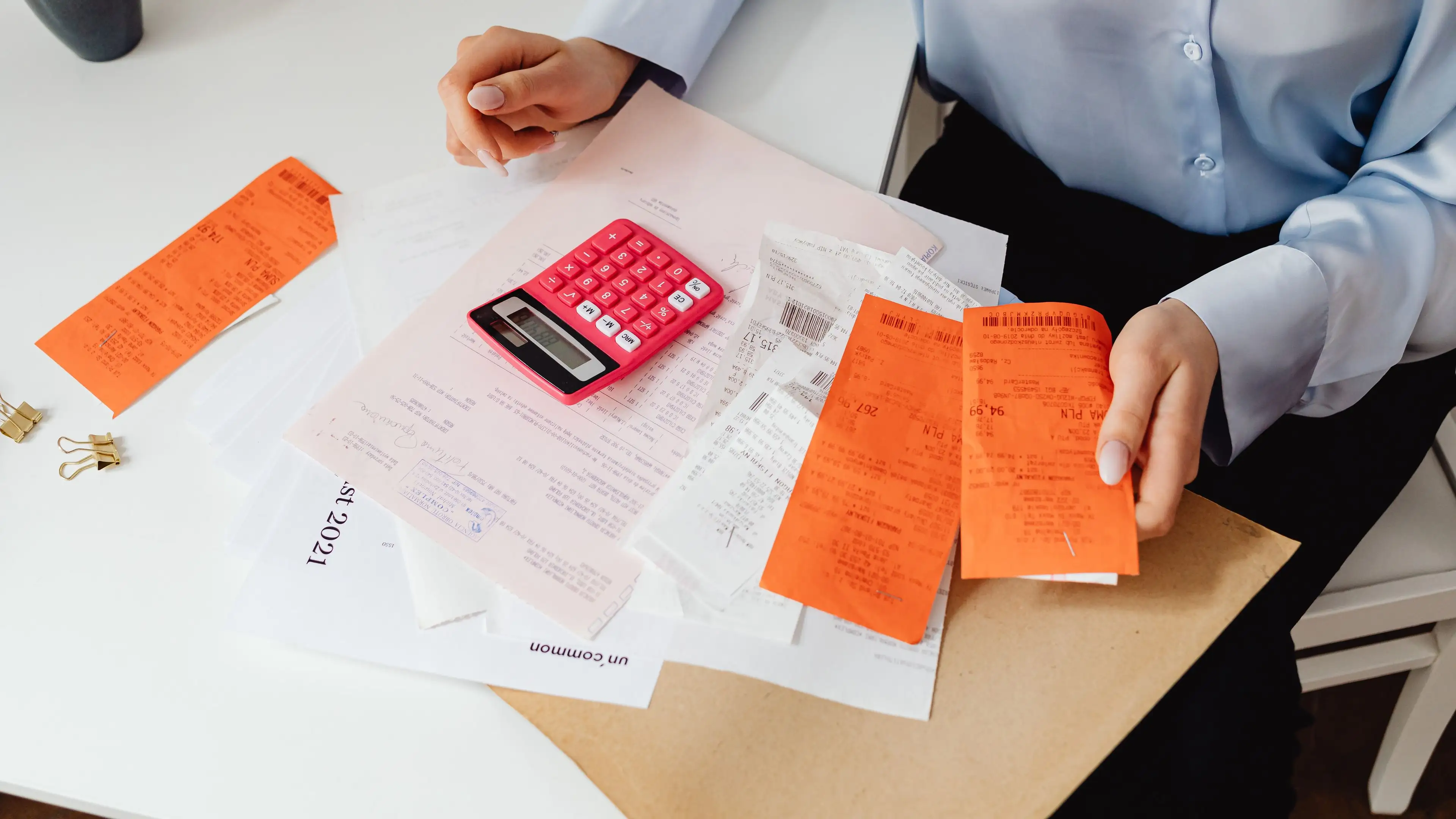 A pile of paper receipts and a calculator on a desk